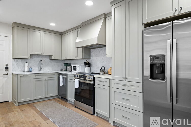 A kitchen with a refrigerator on the right and a sink in the middle.