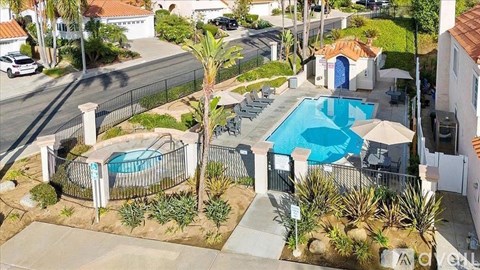 A pool surrounded by a fence and plants.