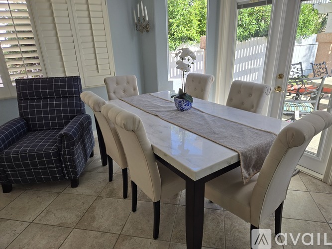 A dining room with a table and chairs.