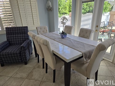 A dining room with a table and chairs.