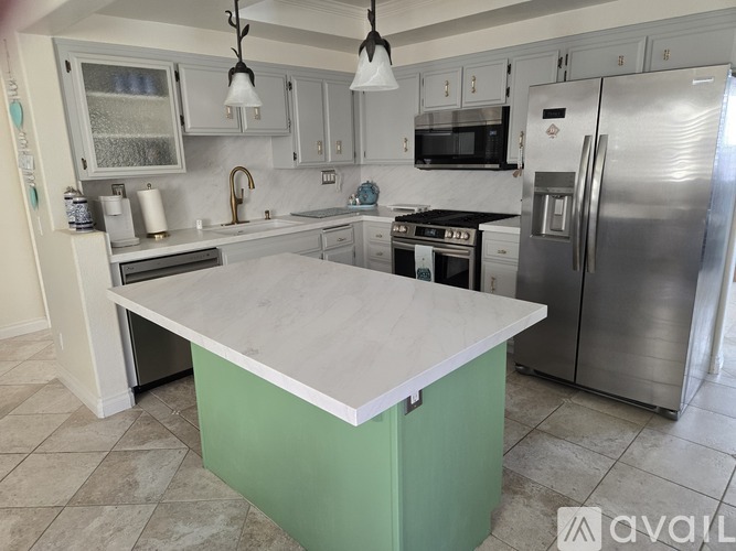 A kitchen with a green island in the middle of it.