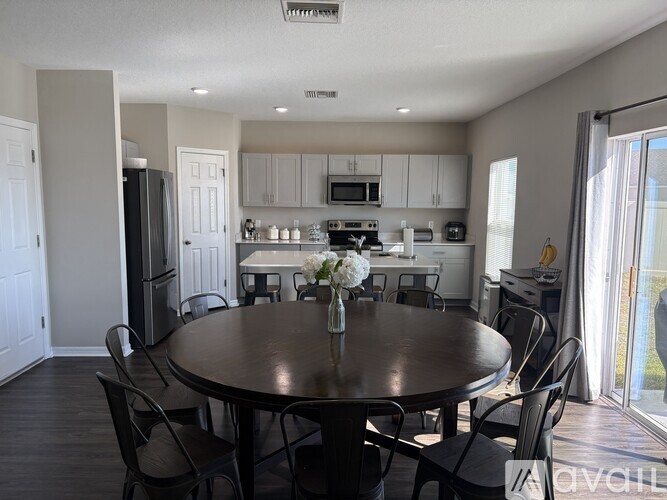 A kitchen with a table and chairs in the foreground.