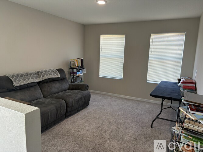 A living room with a grey couch and a black table.