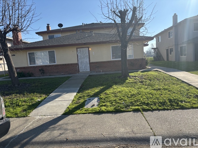 A house with a white door and a tree in front of it.