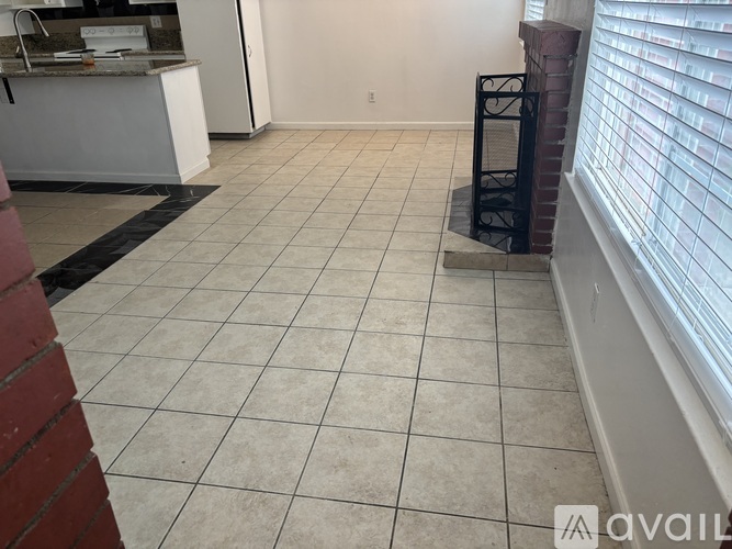 A kitchen area with a white counter and a tiled floor.