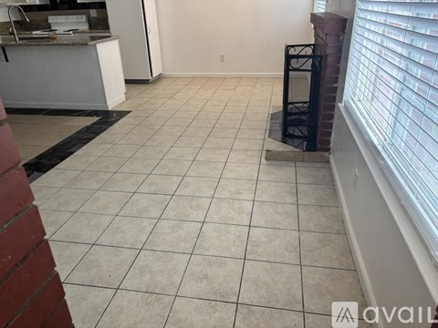 A kitchen area with a white counter and a tiled floor.