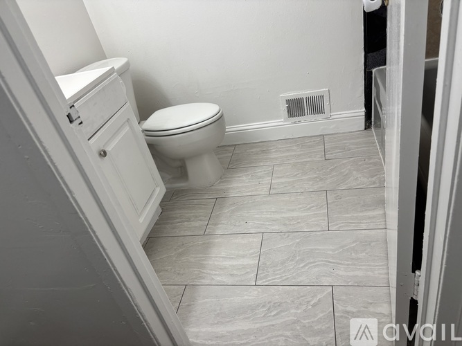 A room with a tiled floor and a window with blinds.