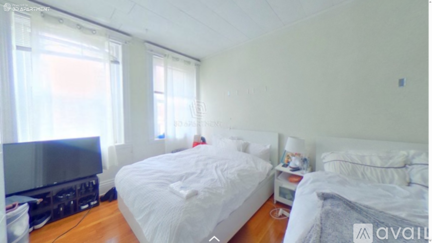 A bedroom with two beds and a television.