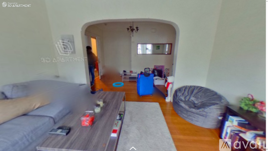 A living room with a grey couch and a blue ottoman.