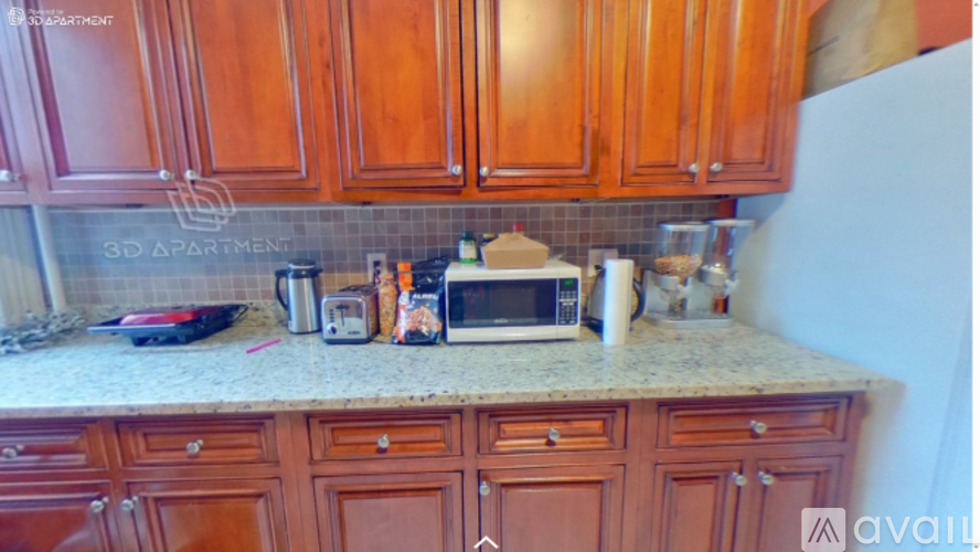 A kitchen with brown cabinets and a granite countertop.