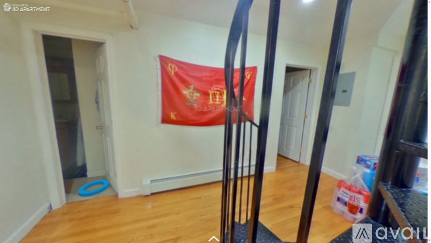 A red flag with a crest hangs on a wall in a room.