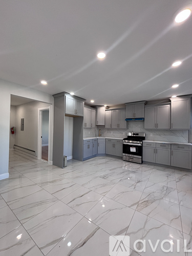 A spacious kitchen with marble flooring and modern appliances.