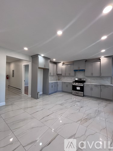 A spacious kitchen with marble flooring and modern appliances.