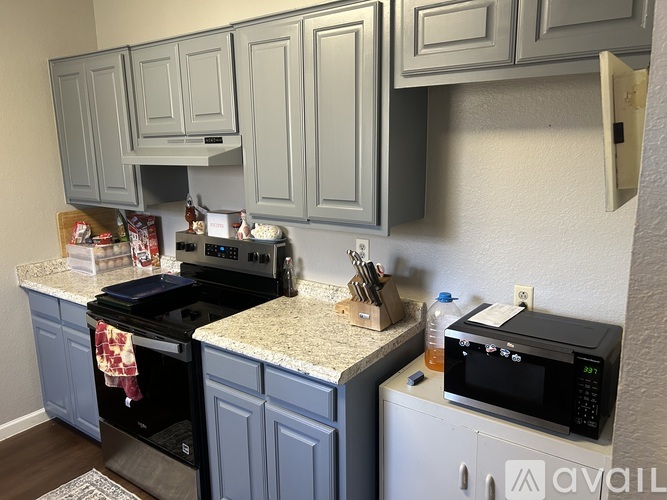 A kitchen with a black stove top oven and a black microwave.