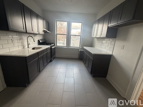 A kitchen with black cabinets and a white fridge.