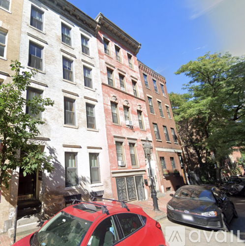 A red car is parked in front of a building.