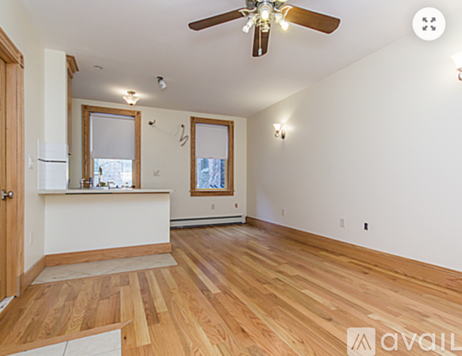A room with wooden floors and a ceiling fan.