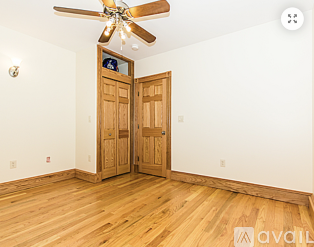 A room with wooden floors and a ceiling fan.