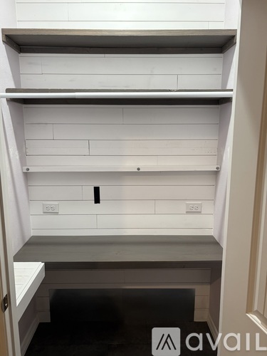 A white kitchen cabinet with a black handle.