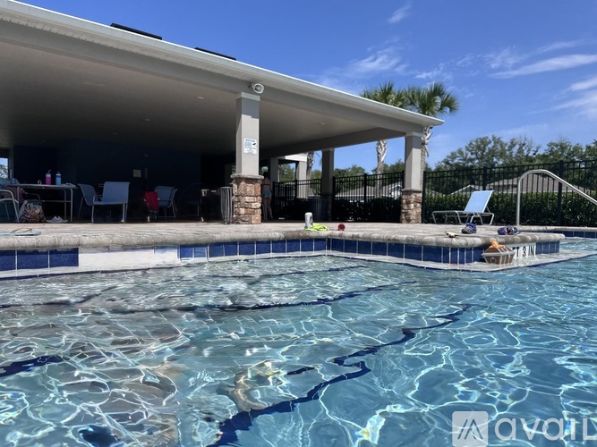 A pool with a white building overlooking it.