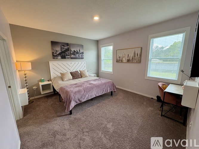 A bedroom with a bed, desk, and chair.