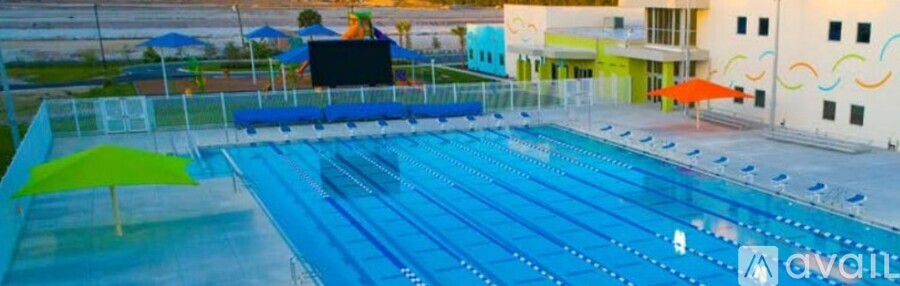 A large blue swimming pool with a white building in the background.