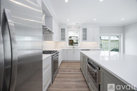 A modern kitchen with a large refrigerator and stainless steel appliances.