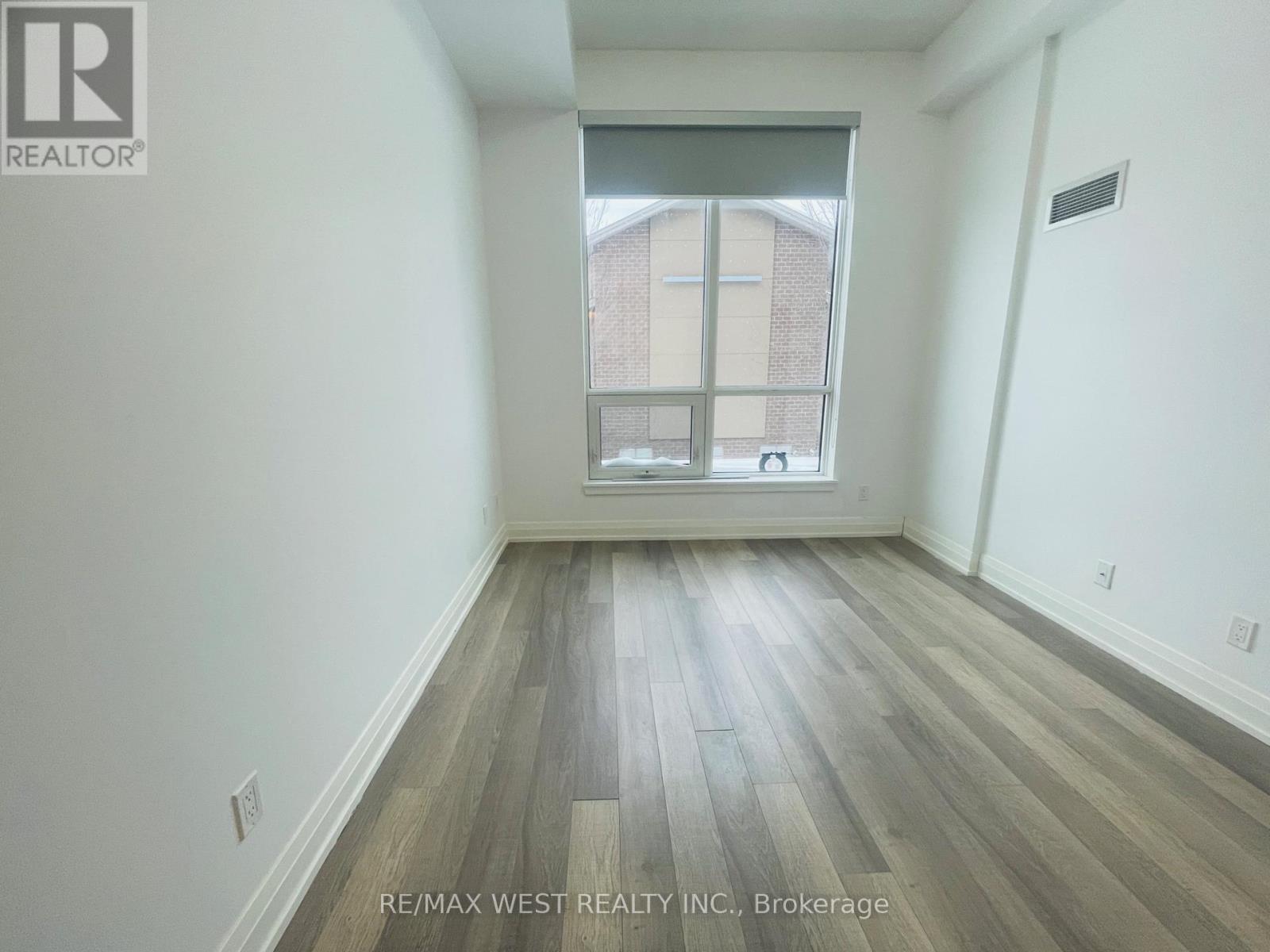 A room with a window and wooden flooring.