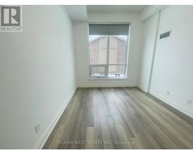 A room with a window and wooden flooring.