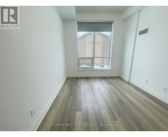 A room with a window and wooden flooring.