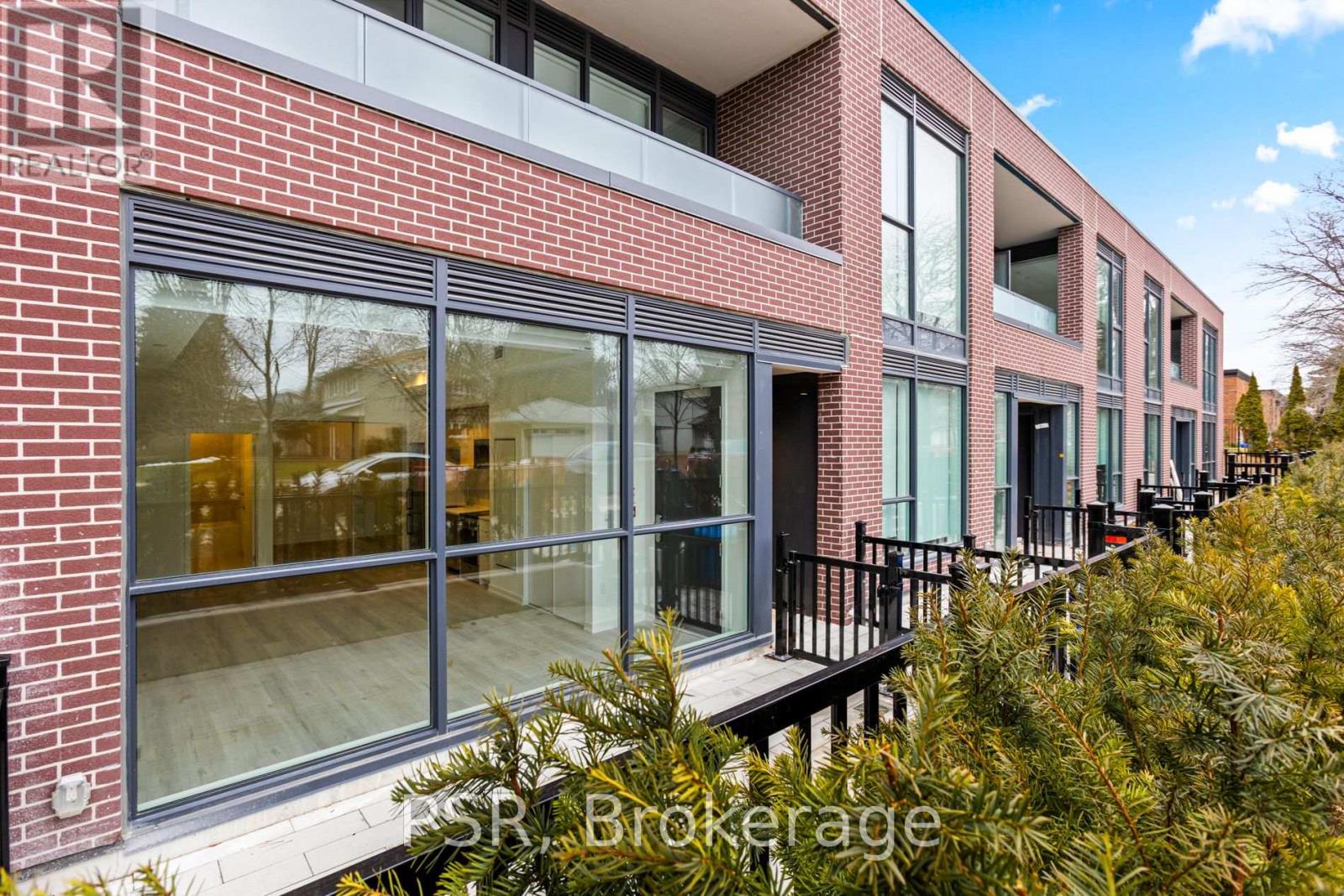 A red brick building with large windows and a balcony.