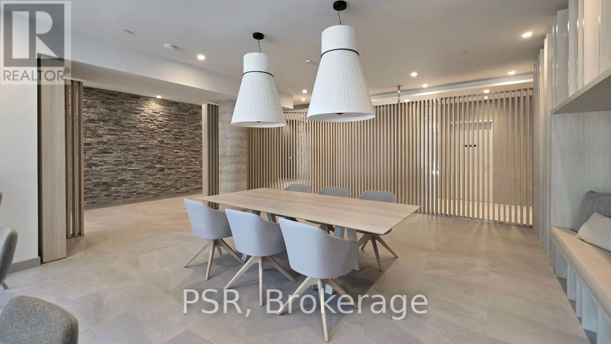 A modern dining room with a stone wall and a long table with chairs.