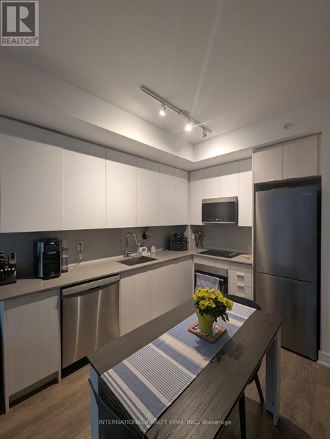A kitchen with a wooden table and a vase of flowers on it.