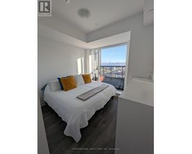 A bedroom with a large bed and a view of the city.