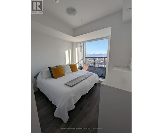A bedroom with a large bed and a view of the city.