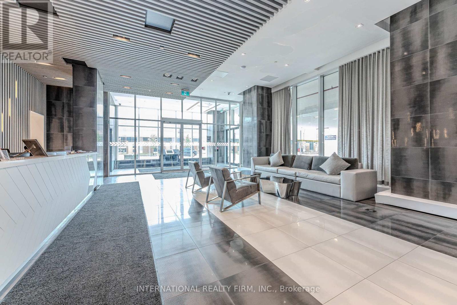 A spacious office lobby with a reception desk and comfortable seating areas.