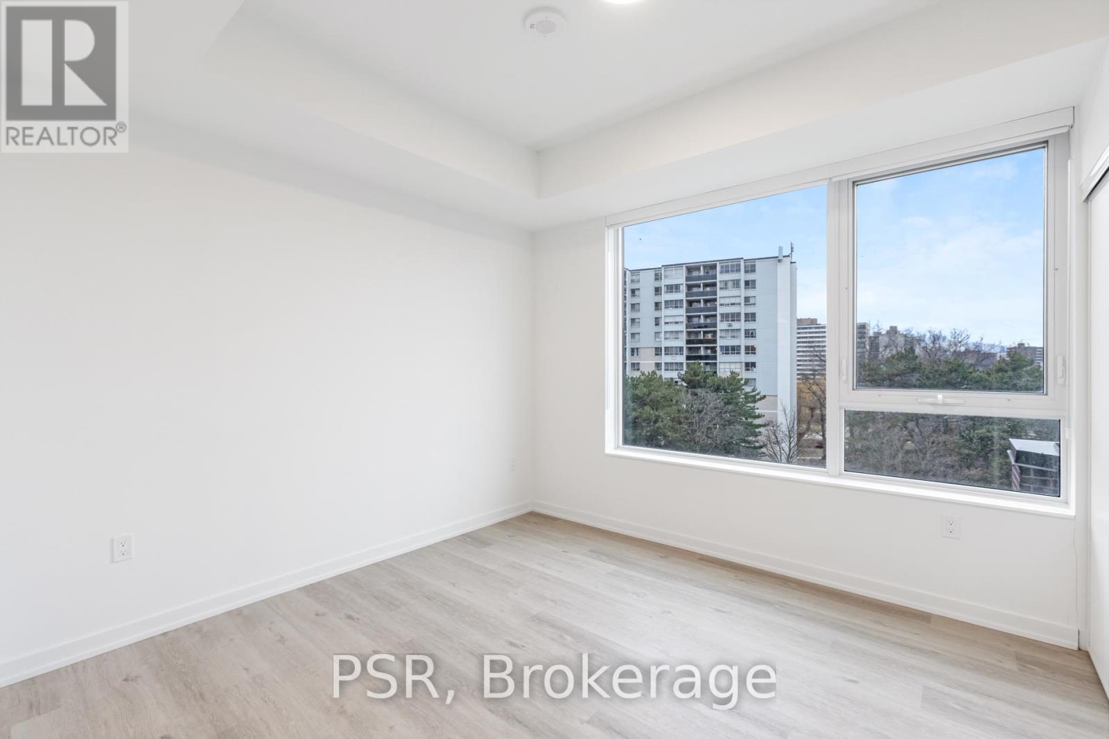 A room with a large window and a view of a building outside.