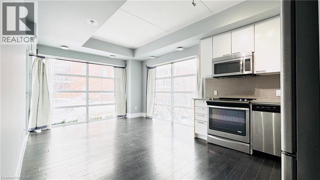 A modern kitchen with stainless steel appliances and a large window.