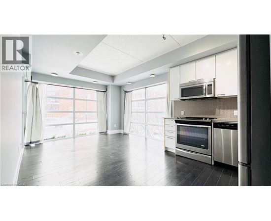 A modern kitchen with stainless steel appliances and a large window.