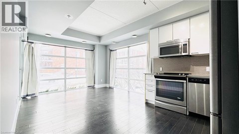 A modern kitchen with stainless steel appliances and a large window.
