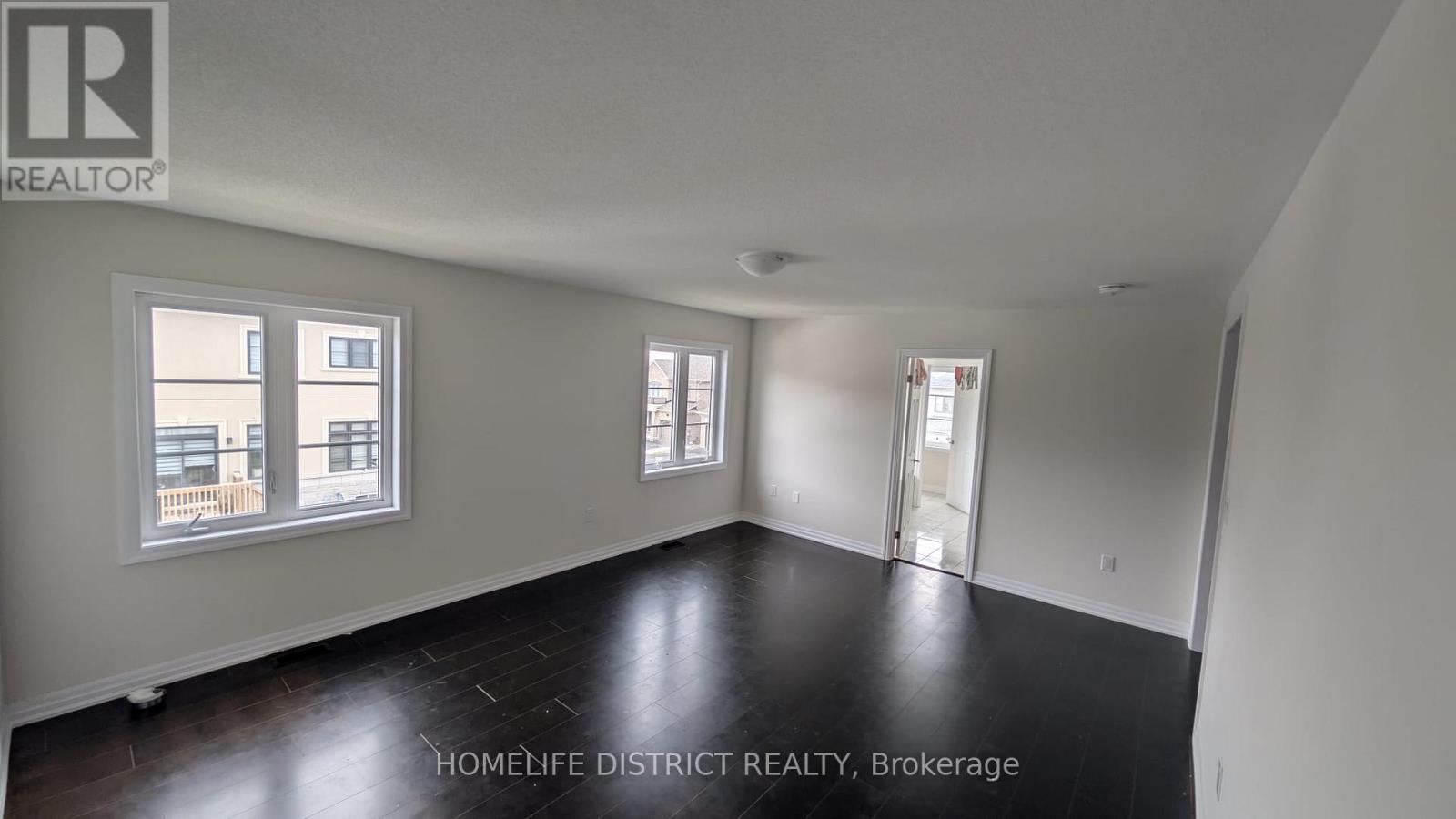 A room with a brokerage sign on the wall.