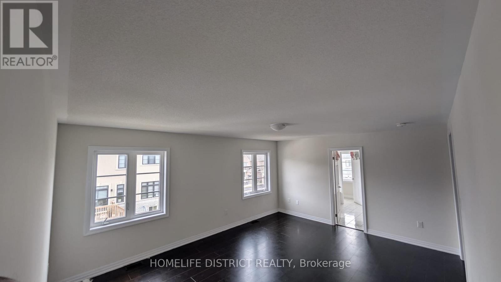 A room with a window overlooking a building.