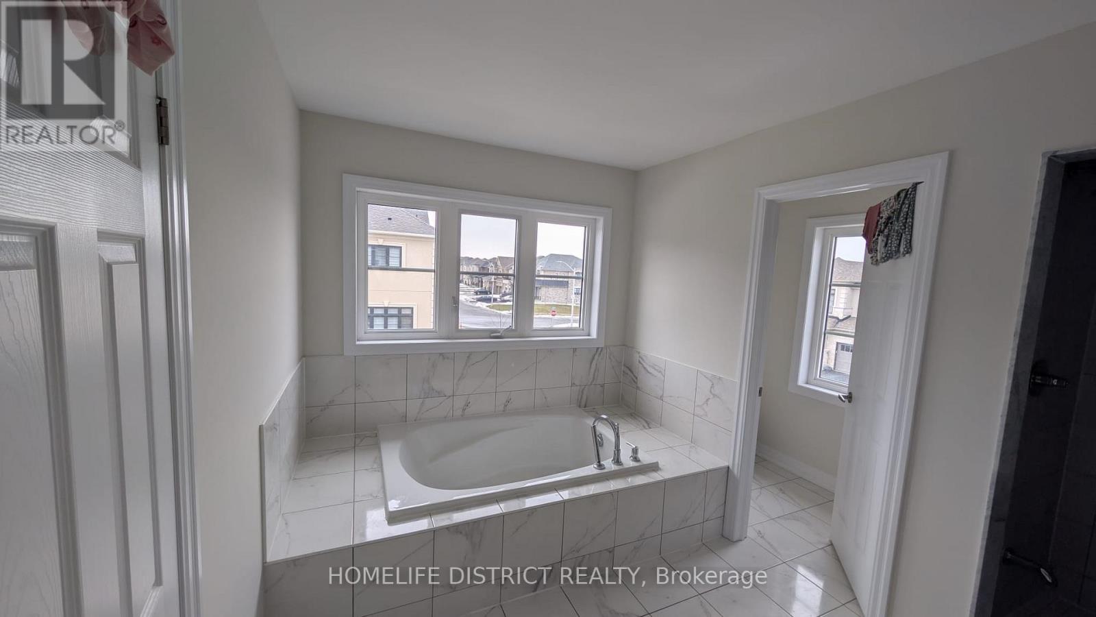 A bathroom with a tub and a window.