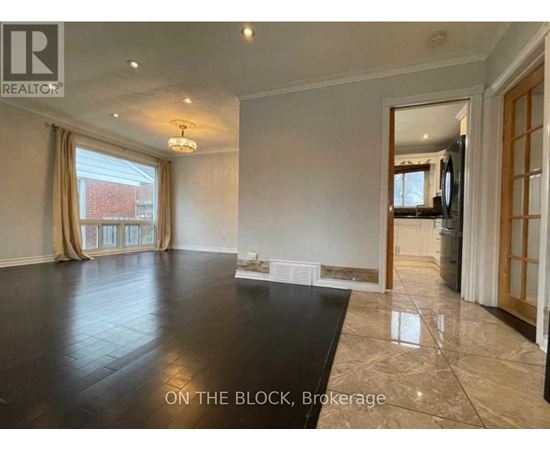 A spacious living room with a large black table and a television in the corner.
