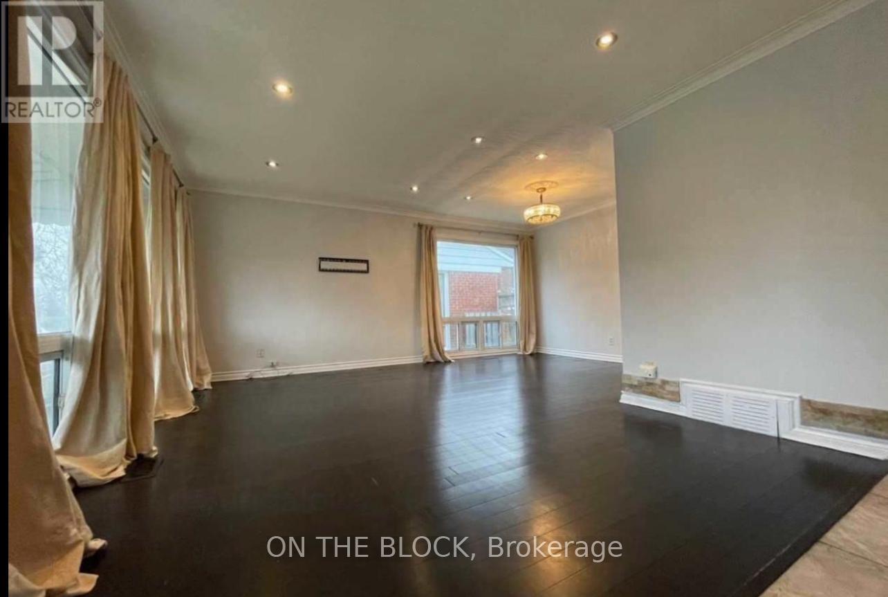 A spacious room with a black floor and beige curtains.