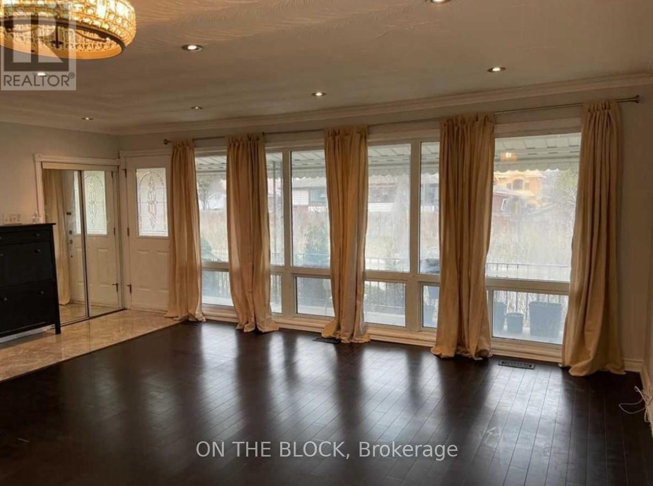 A spacious room with a large window and a flat-screen TV.