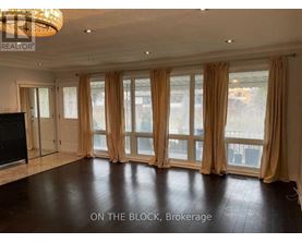 A spacious room with a large window and a flat-screen TV.