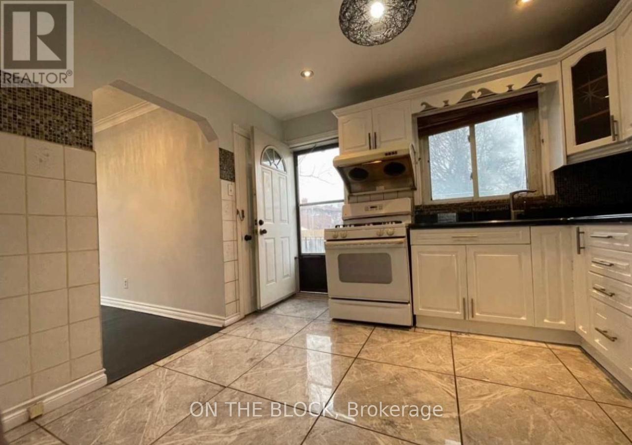 A kitchen with a tiled floor and a stove top oven.