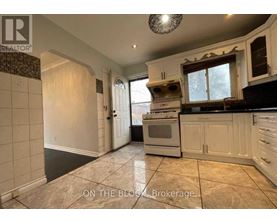 A kitchen with a tiled floor and a stove top oven.
