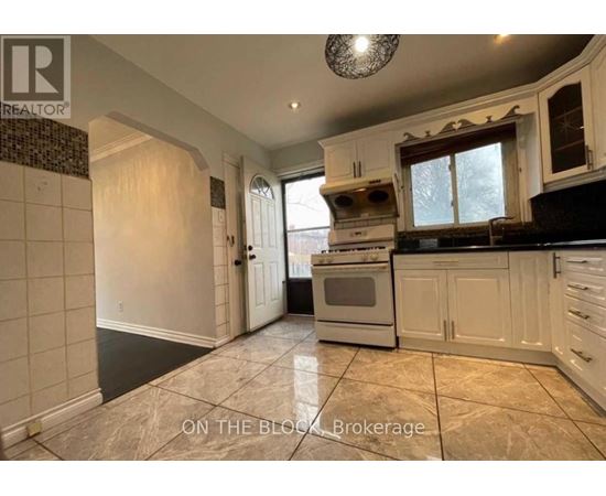 A kitchen with a tiled floor and a stove top oven.